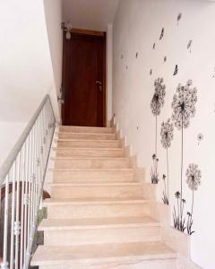 eine Treppe mit Holztür und Blumen an der Wand in der Unterkunft Villa Hermosa in Alghero