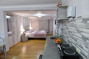 Pokój z łóżkiem i kuchnią z kuchenką w obiekcie Cozy House w Kutaisi