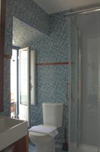 a bathroom with a toilet and a sink and a shower at Vinnus Guesthouse in Ericeira