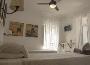 a bedroom with a bed and a ceiling fan at Vinnus Guesthouse in Ericeira