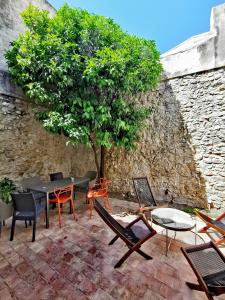 un patio con sedie, tavolo e albero di L ORANGER - Plein centre - 6 Personnes - Clim a Cassis