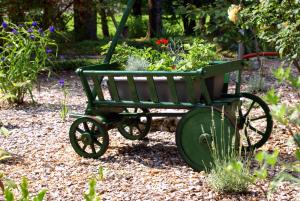 ein grüner Wagen voller Pflanzen im Garten in der Unterkunft Apartments Leni in Postojna