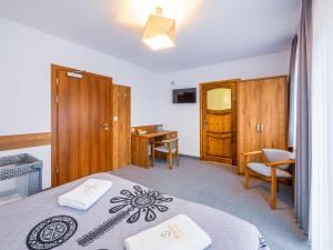 a bedroom with a bed and a desk and a table at Strama Kościelisko in Kościelisko