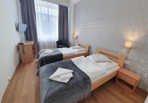 een hotelkamer met 2 bedden in een kamer bij Hotel Preveza in Spišská Nová Ves