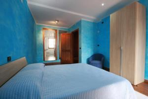 a bedroom with blue walls and a large bed at B&B Linu Ruiu in Santu Lussurgiu