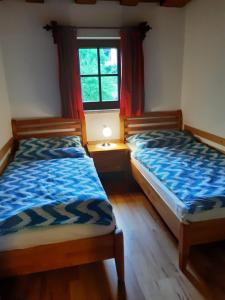 twee bedden in een kamer met een raam bij Haus Moser in Altaussee