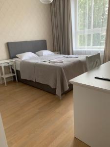 um quarto com uma cama, uma mesa e uma janela em Rohuaia Apartments em Rakvere