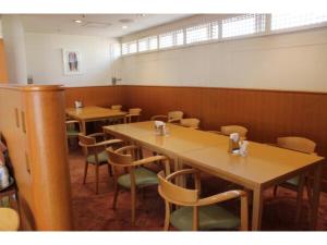 uma sala de jantar com mesas e cadeiras de madeira em Mizusawa Ground Hotel - Vacation STAY 84949 em Oshu