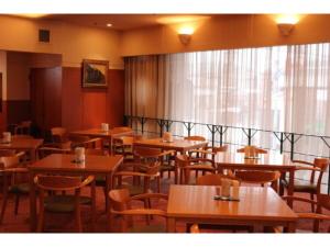 a dining room with wooden tables and chairs at Mizusawa Ground Hotel - Vacation STAY 84945 in Oshu