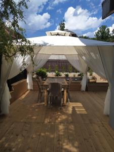 a table and chairs under a white canopy on a deck at Apartament KAOLA in Jelenia Góra