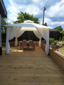 a white canopy over a patio with a table and chairs at Apartament KAOLA in Jelenia Góra