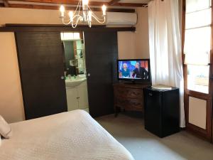 een slaapkamer met een bed en een tv op een dressoir bij La Marjolaine in Juan-les-Pins