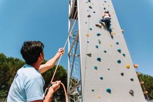 un hombre en un muro de escalada con una mujer en él en Casas de Pedra - Quinta da Escola, en Alvados