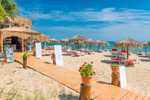 einen Strand mit Liegestühlen und Sonnenschirmen und dem Meer in der Unterkunft Iris Beach Hotel in Sweti Wlas