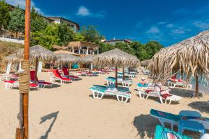 eine Gruppe von Stühlen und Sonnenschirmen am Strand in der Unterkunft Iris Beach Hotel in Sweti Wlas