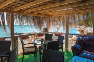 Zimmer mit einem Tisch und Stühlen sowie Blick auf das Wasser in der Unterkunft Iris Beach Hotel in Sweti Wlas