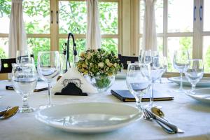 - une table avec des verres à vin et un vase de fleurs dans l'établissement Pension Passion, à Târgu-Mureş