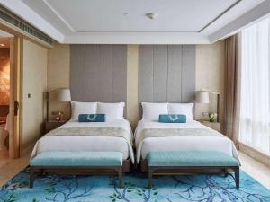 Cama ou camas em um quarto em Raffles Jakarta