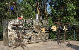 um balcão de metal com dois bancos e uma mesa em CASA BEACHCOMBER Le jardin des Arts em Lagos