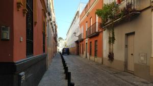 un vicolo con una macchina che guida lungo una strada di Apartamento Torres19 a Siviglia