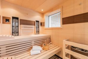 ein Holzbadezimmer mit einer Badewanne und einem Fenster in der Unterkunft Löwen Chalets in Seefeld in Tirol