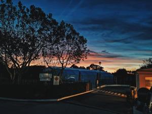 un tren está estacionado junto a una valla al atardecer en Camping Villa Park Zambujeira do Mar, en Zambujeira do Mar