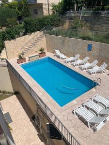 une piscine avec des chaises longues et une piscine dans l'établissement Apartments Toni 2000, à Podstrana