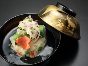 ein schwarzer Teller mit einem Stück Essen mit einem Löffel in der Unterkunft Wakasa Annex in Nara