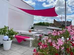 une terrasse avec une table de pique-nique et des fleurs roses dans l'établissement Business Hotel Wiesbaden PRIME, à Wiesbaden