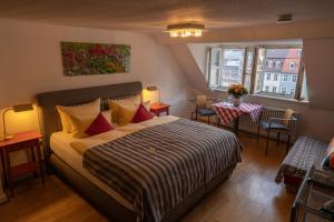 - une chambre avec un lit et une table avec des chaises dans l'établissement Hotel Goldener Falke, à Heidelberg