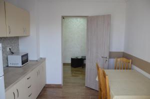 APARTAMENT RAZVAN HOLIDAY COSTINESTI في كوستينيشت: مطبخ مع طاوله وباب للغرفه