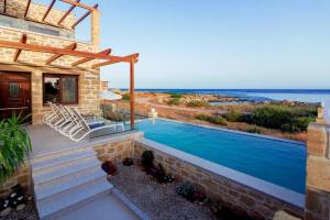 - une piscine dans une maison avec vue sur l'océan dans l'établissement Athinais villa, à Paleóchora