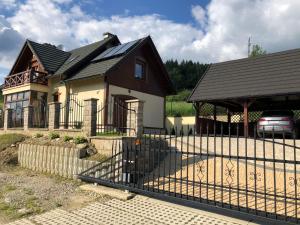 una casa con una recinzione di fronte di Dom Na Stoku - Hillside Cottage Eliza a Szczawnica