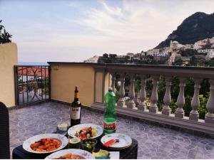 - une table avec des assiettes de nourriture et 2 bouteilles de vin dans l'établissement Casa Tutti Frutti, à Positano