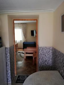 Blick auf ein Zimmer mit einem Bett und einem Wohnzimmer in der Unterkunft Csilla Apartman in Makó