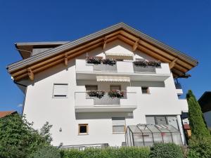 ein weißes Gebäude mit Blumenkästen auf den Balkonen in der Unterkunft Appartements Oberleiter in Olang