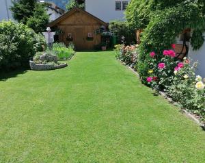 einen Garten mit Blumen vor einem Haus in der Unterkunft Appartements Oberleiter in Olang