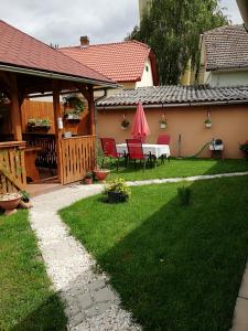 eine Terrasse mit einem Tisch und Stühlen im Hof in der Unterkunft Csilla Apartman in Makó