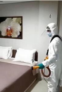 een persoon in een kamer met een bed bij Lis Hotel in Teresina