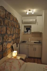 uma cozinha e uma sala de estar com uma parede de pedra em Apartments Lucic em Dubrovnik