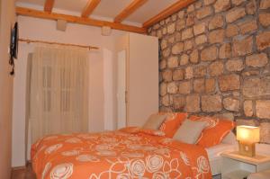 um quarto com uma parede de pedra e uma cama em Apartments Lucic em Dubrovnik