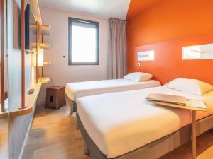 A bed or beds in a room at ibis budget Beauvais Aeroport