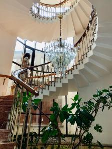 a staircase with a chandelier in a building at Hotel Victoria in Cluj-Napoca