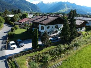 une vue aérienne sur une maison avec des voitures garées dans une allée. dans l'établissement Pension Alpentraum, à Zell am See