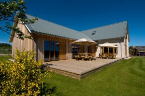 un bâtiment avec une terrasse dotée de tables et de parasols dans l'établissement Clovenstone Lodges, à Inverurie