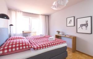 Un dormitorio con una cama roja y blanca y una ventana en WÄLDER: Quartier Titisee, en Titisee-Neustadt