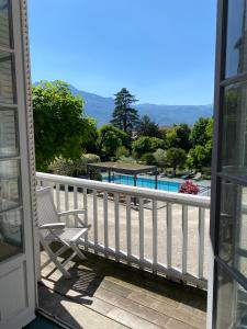 a balcony with a chair and a swimming pool at Château & Spa De La Commanderie in Eybens