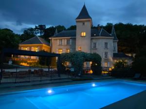 a large house with a swimming pool in front of it at Château & Spa De La Commanderie in Eybens