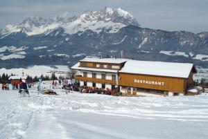 サンクト・ジョアン・イン・チロルにあるAlpengasthof Hirschbergの雪上の人々の集まりを持つスキー場