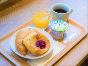 um prato de pequeno-almoço com um produto de pastelaria e uma chávena de café e sumo de laranja em SHIN YOKOHAMA SK HOTEL - Non Smoking - Vacation STAY 86111 em Yokohama